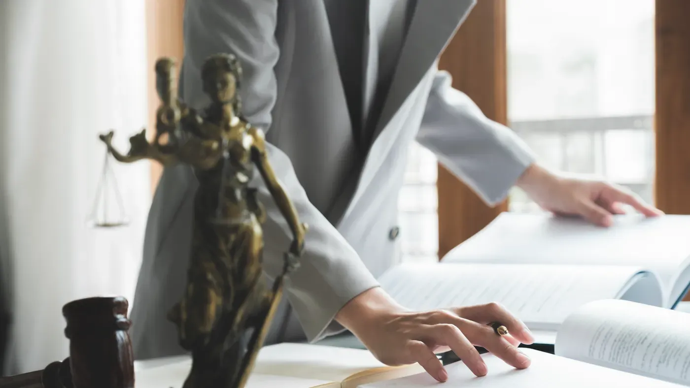 A set of scales beside legal books while someone works through documents
