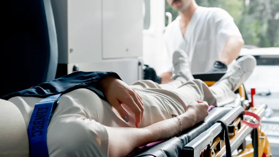 A patient on a stretcher being attended to in an ambulance